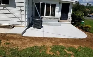 Freshly poured concrete patio and walkway beside a Lehigh Valley home